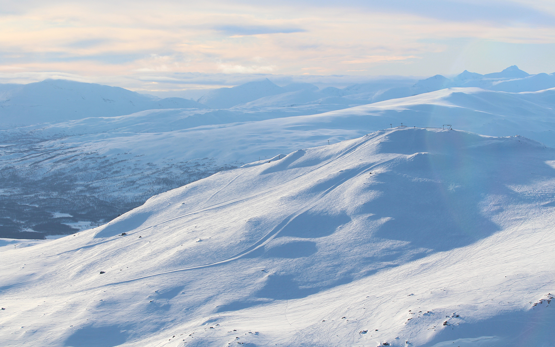 White mountains with a ski lift and slopes. 
