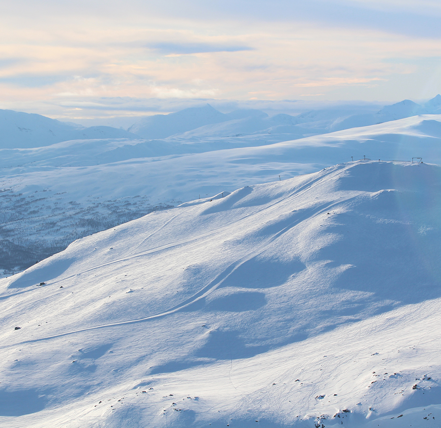 White mountains with a ski lift and slopes. 