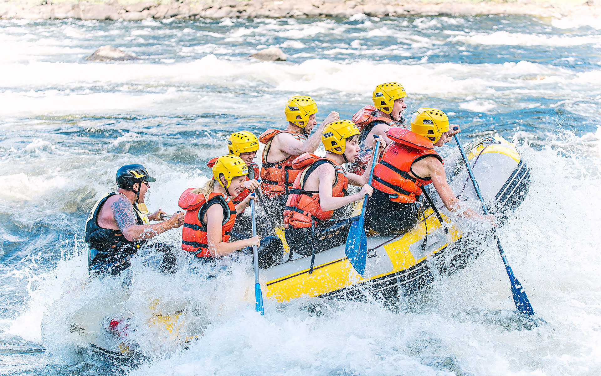 People river rafting. Water splashing all around. 